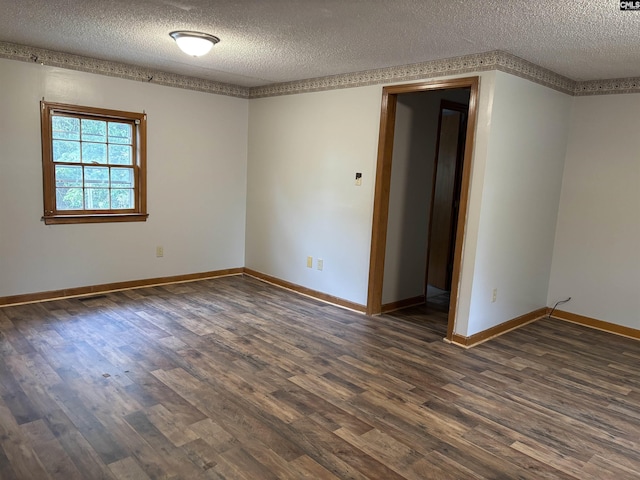 spare room with dark wood-type flooring, baseboards, and a textured ceiling