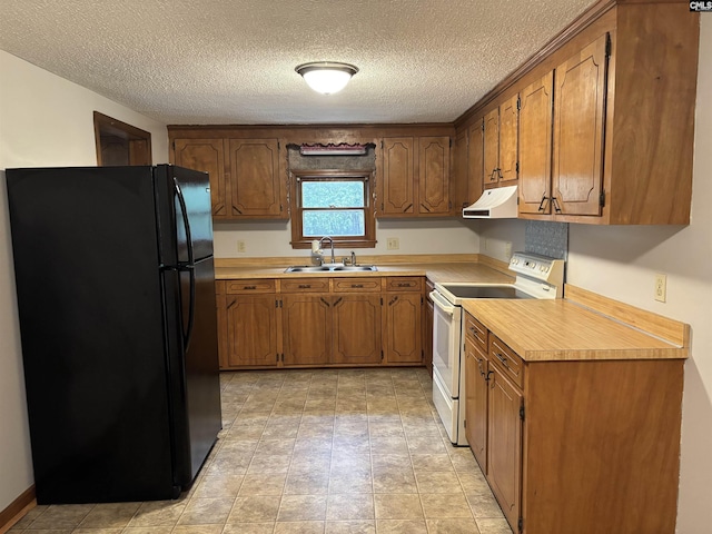 kitchen featuring light countertops, a sink, freestanding refrigerator, white electric range, and under cabinet range hood
