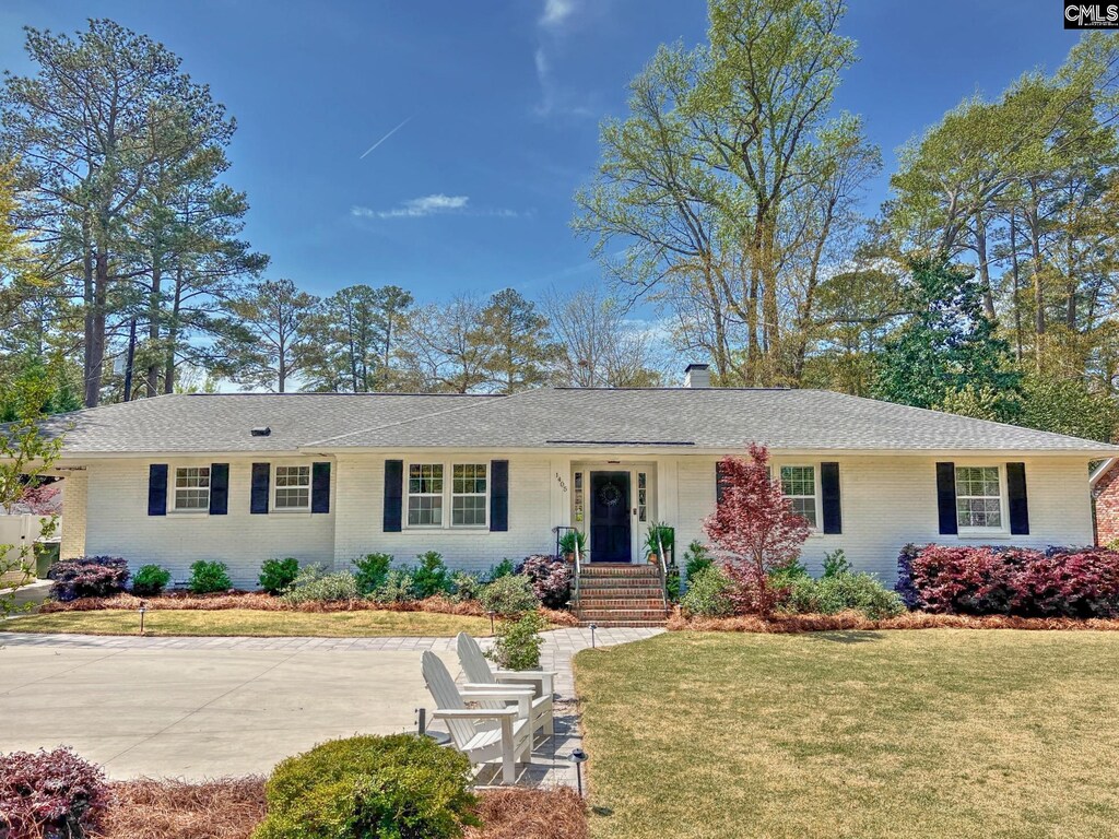 1405 Ivy Ln, Columbia, SC 29204 - ranch-style house with brick siding, a front yard, a shingled roof, and a chimney