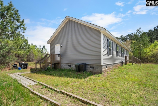 view of side of property featuring crawl space and a yard