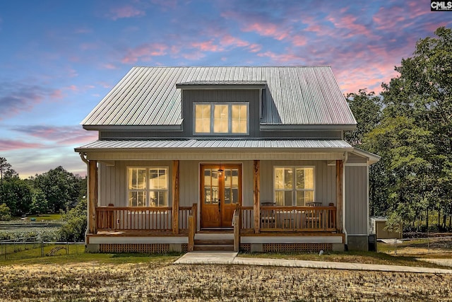 view of front of property with metal roof, covered porch, and board and batten siding