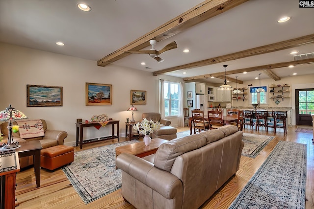 living area with light wood-style flooring, recessed lighting, baseboards, beamed ceiling, and a ceiling fan