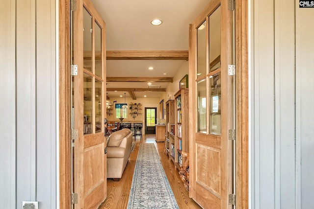 hallway with light wood finished floors, recessed lighting, and beam ceiling