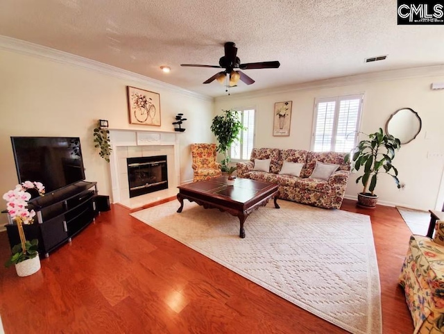 103 Saddlechase Ln, Columbia, SC 29223 - living area with a tile fireplace, a ceiling fan, wood finished floors, visible vents, and ornamental molding