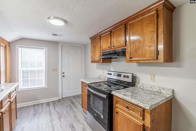 1565 Mayer St, Columbia, SC 29203 - kitchen featuring light countertops, stainless steel range with electric stovetop, brown cabinets, light wood-type flooring, and under cabinet range hood