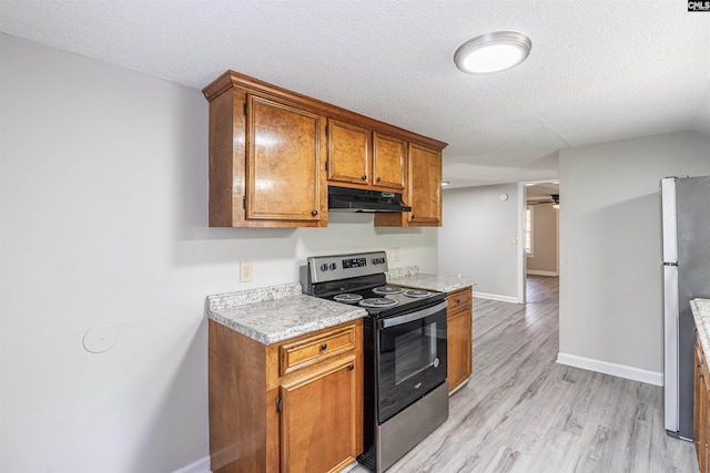 1565 Mayer St, Columbia, SC 29203 - kitchen featuring light countertops, appliances with stainless steel finishes, under cabinet range hood, light wood-type flooring, and brown cabinetry