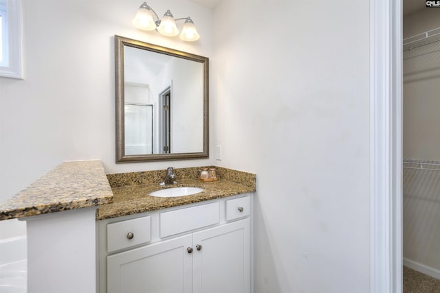 full bathroom with a spacious closet and vanity