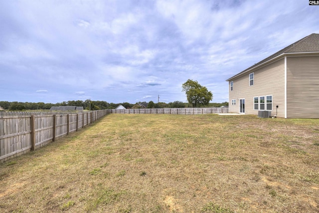 view of yard with a fenced backyard and central air condition unit