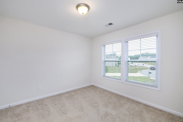 carpeted spare room with baseboards and visible vents