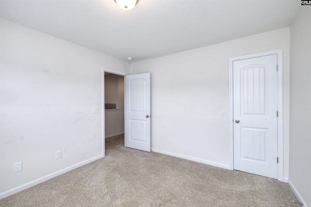unfurnished bedroom featuring carpet floors and baseboards