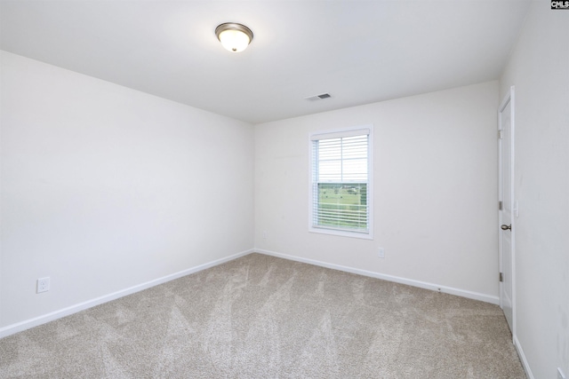 carpeted spare room featuring baseboards and visible vents