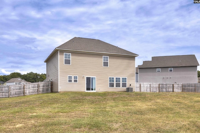 back of house with a fenced backyard, central AC unit, and a yard