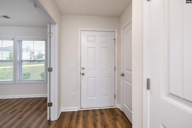 doorway to outside featuring dark wood finished floors, baseboards, and visible vents