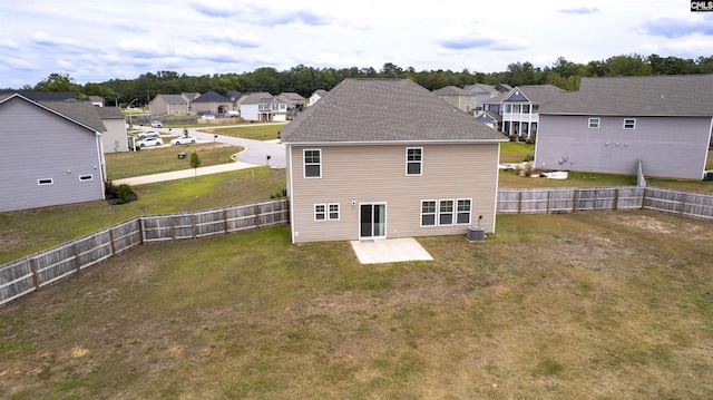 back of property featuring a fenced backyard, a residential view, a patio area, and a lawn