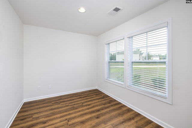 empty room featuring baseboards, recessed lighting, visible vents, and dark wood-type flooring