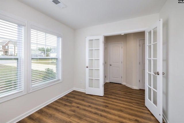 empty room with baseboards, visible vents, french doors, and dark wood-style flooring