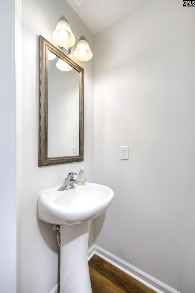 bathroom with baseboards and wood finished floors