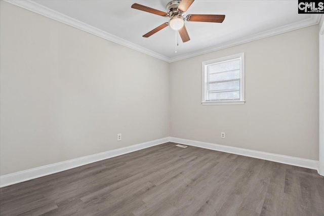 spare room with a ceiling fan, ornamental molding, dark wood-style floors, and baseboards