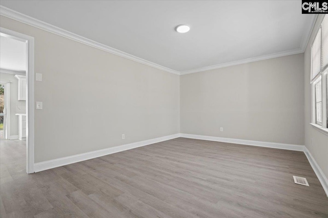 unfurnished room featuring a wealth of natural light, crown molding, and visible vents