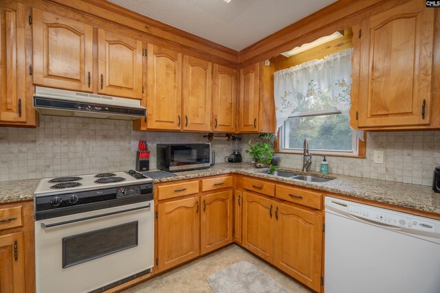 2008 Arnett Dr, Camden, SC 29020 - kitchen with tasteful backsplash, white appliances, under cabinet range hood, a sink, and brown cabinets