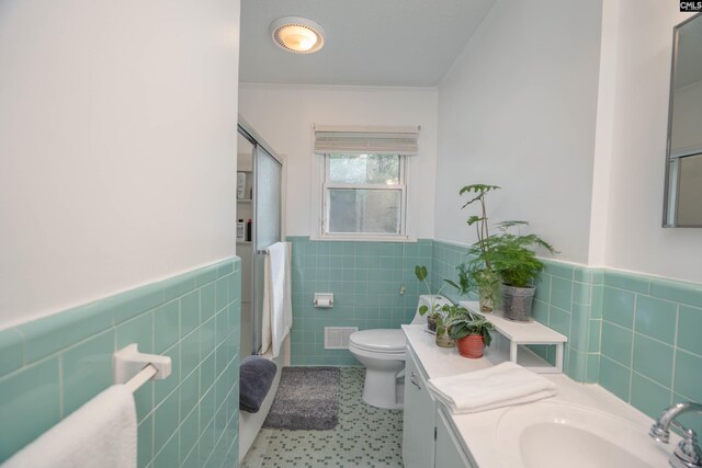 2008 Arnett Dr, Camden, SC 29020 - full bath featuring toilet, vanity, a shower with door, visible vents, and tile walls