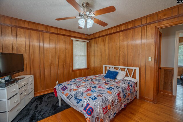 2008 Arnett Dr, Camden, SC 29020 - bedroom with a textured ceiling, wood finished floors, a ceiling fan, and wooden walls