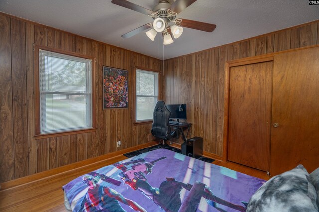 2008 Arnett Dr, Camden, SC 29020 - bedroom with a closet, wood finished floors, wood walls, baseboards, and ceiling fan