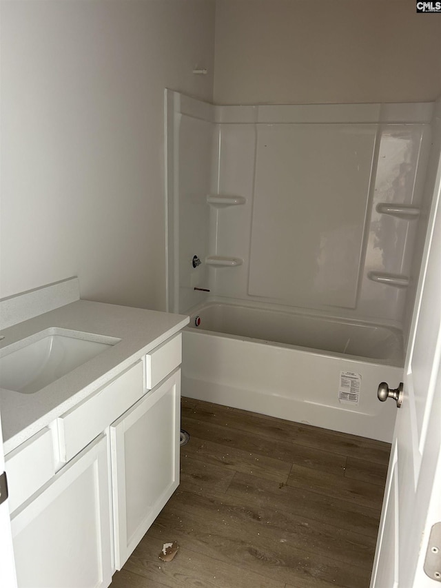 full bathroom featuring wood finished floors, vanity, and bathing tub / shower combination