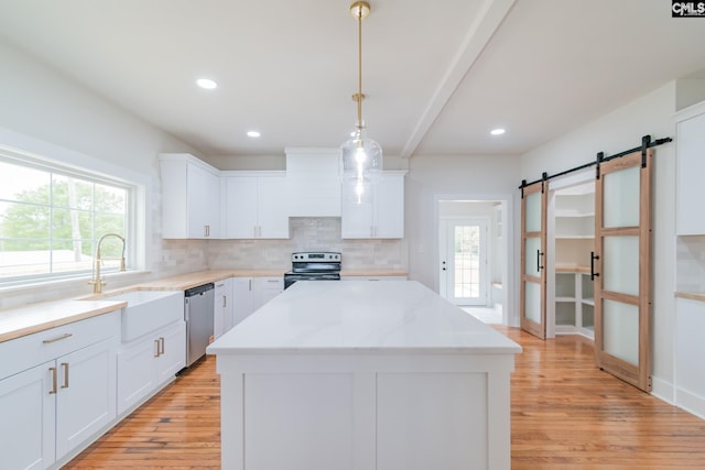 kitchen featuring a sink, electric range oven, a barn door, dishwasher, and premium range hood