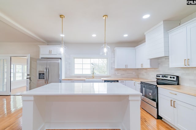 kitchen with light countertops, decorative backsplash, appliances with stainless steel finishes, and light wood-type flooring