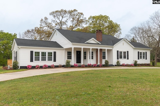 view of front of house with a chimney, a front lawn, concrete driveway, and covered porch