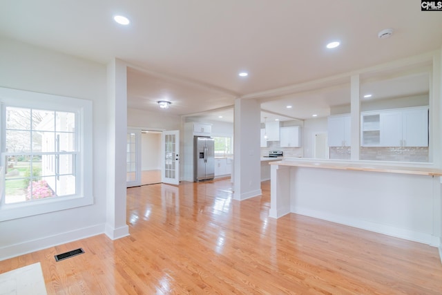 unfurnished living room with baseboards, visible vents, light wood-style floors, and recessed lighting