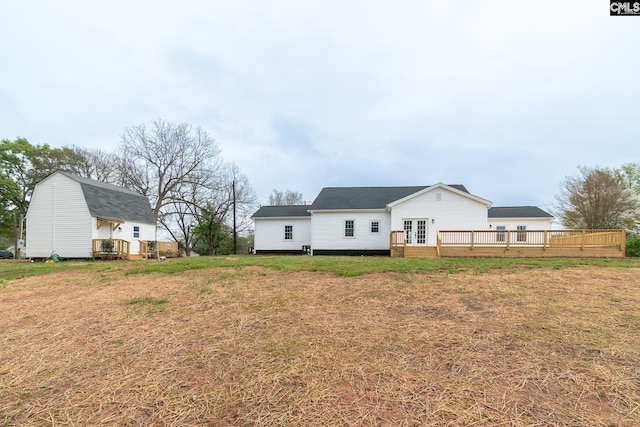 rear view of house with french doors, a yard, and a deck