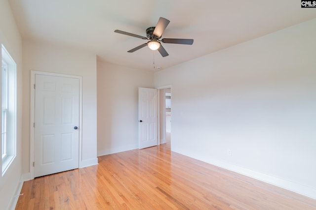 unfurnished room with baseboards, ceiling fan, and light wood-style floors