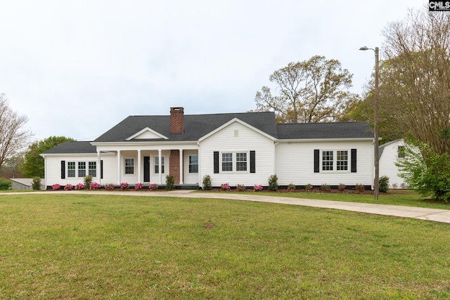 ranch-style home with a front lawn, a chimney, and a porch