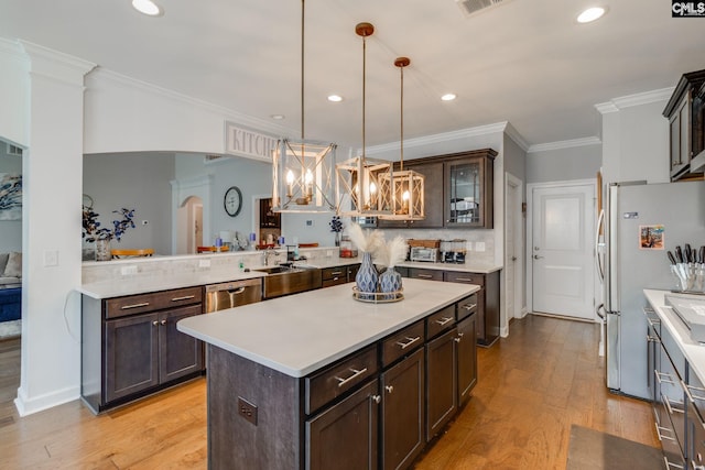 232 Compass Trl, Blythewood, SC 29016 - kitchen with light wood-style flooring, arched walkways, dark brown cabinets, appliances with stainless steel finishes, and light countertops