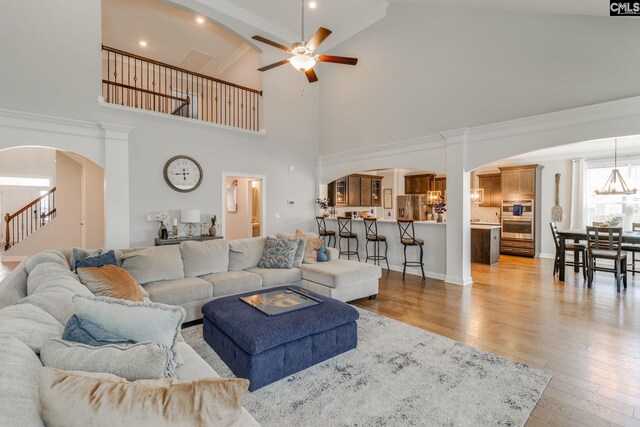 232 Compass Trl, Blythewood, SC 29016 - living room with arched walkways, a ceiling fan, crown molding, stairs, and light wood-style flooring