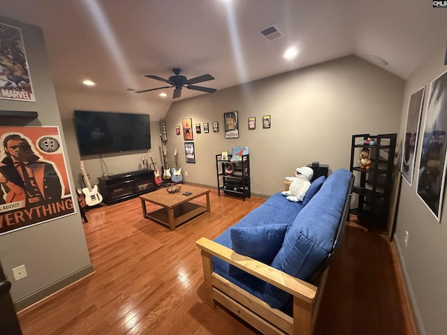 living area with visible vents, ceiling fan, vaulted ceiling, and wood finished floors