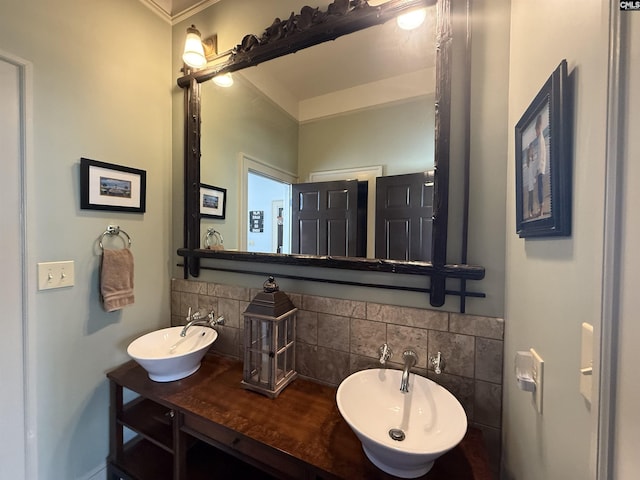 bathroom with a sink, backsplash, and double vanity