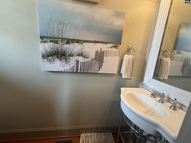 bathroom featuring baseboards and a sink