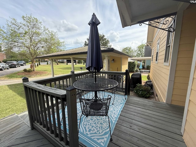 deck with outdoor dining space and a yard
