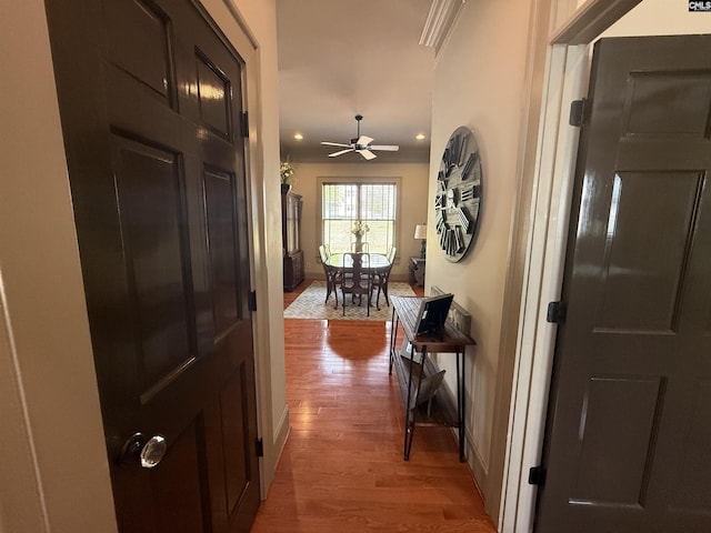 hallway featuring light wood-style flooring and baseboards