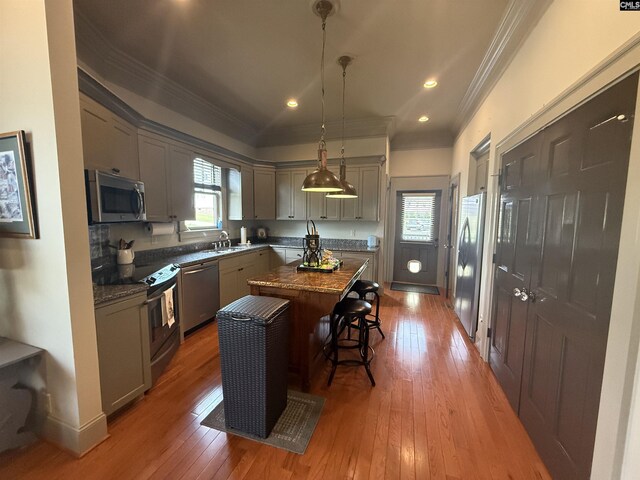 kitchen featuring crown molding, a center island, appliances with stainless steel finishes, and gray cabinetry