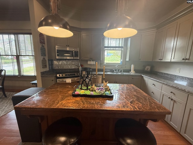 kitchen featuring stainless steel microwave, a breakfast bar area, and wood finished floors