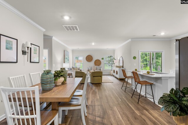 218 Secretariat St, Lexington, SC 29073 - dining space with wood finished floors, ornamental molding, visible vents, and a healthy amount of sunlight