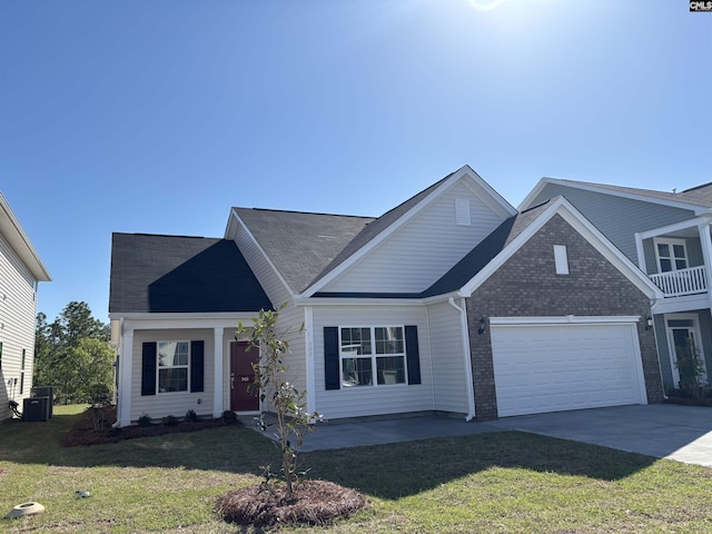 view of front facade with a front lawn, driveway, an attached garage, and brick siding