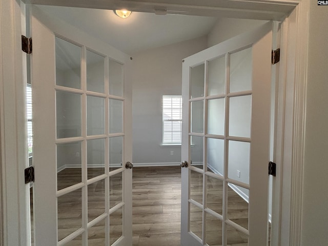 unfurnished room with wood finished floors, french doors, and baseboards