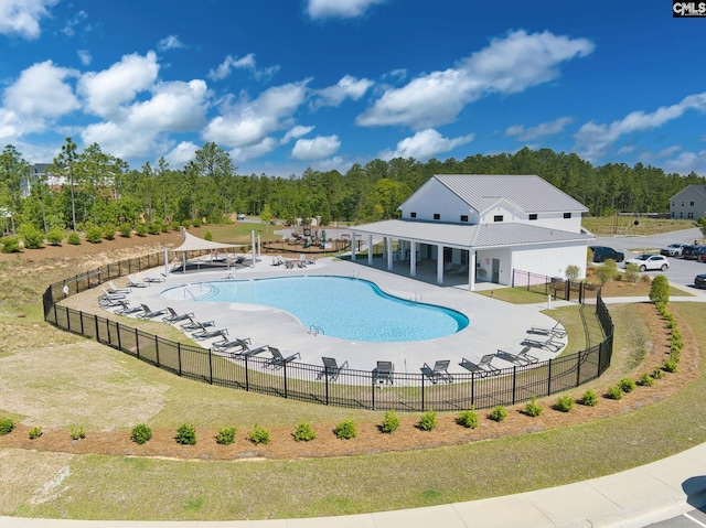 community pool with a patio and fence