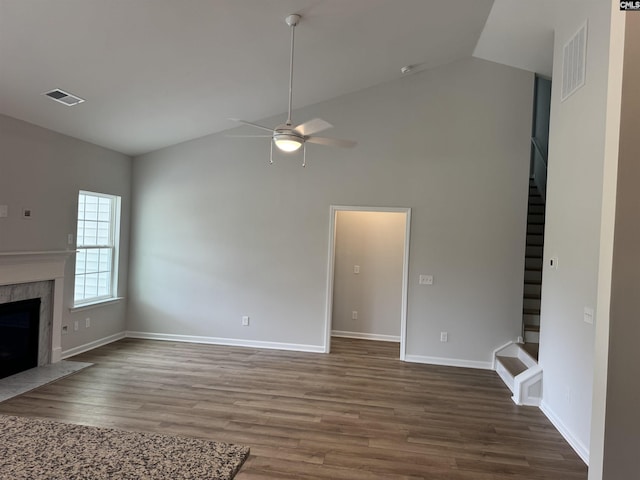 unfurnished living room featuring visible vents, wood finished floors, ceiling fan, and stairs