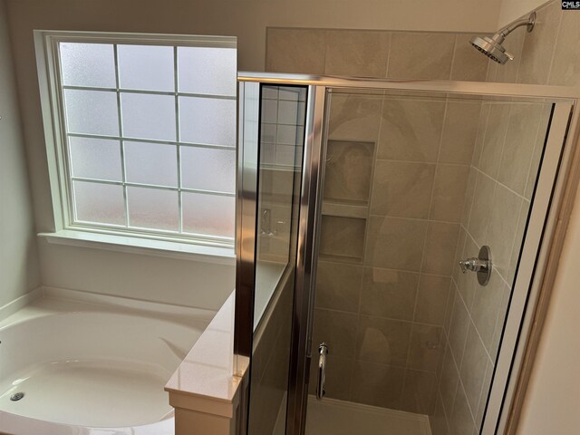bathroom featuring a bath and a stall shower